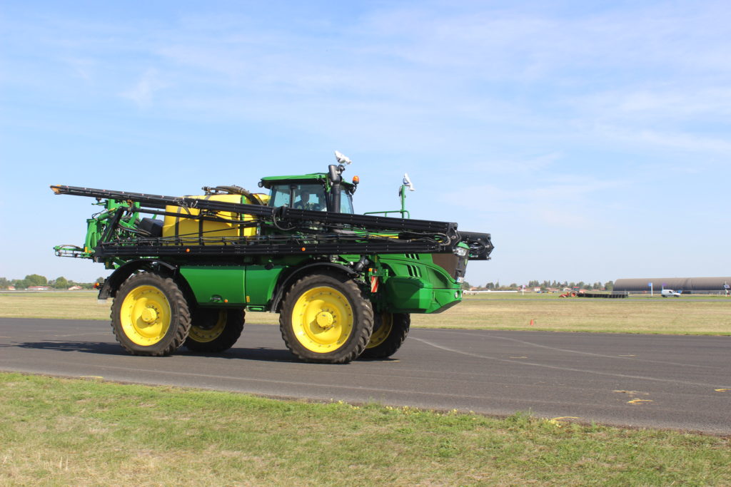 Samojízdný postřikovač John Deere R4140i na asfaltové ploše testovacího polygonu.