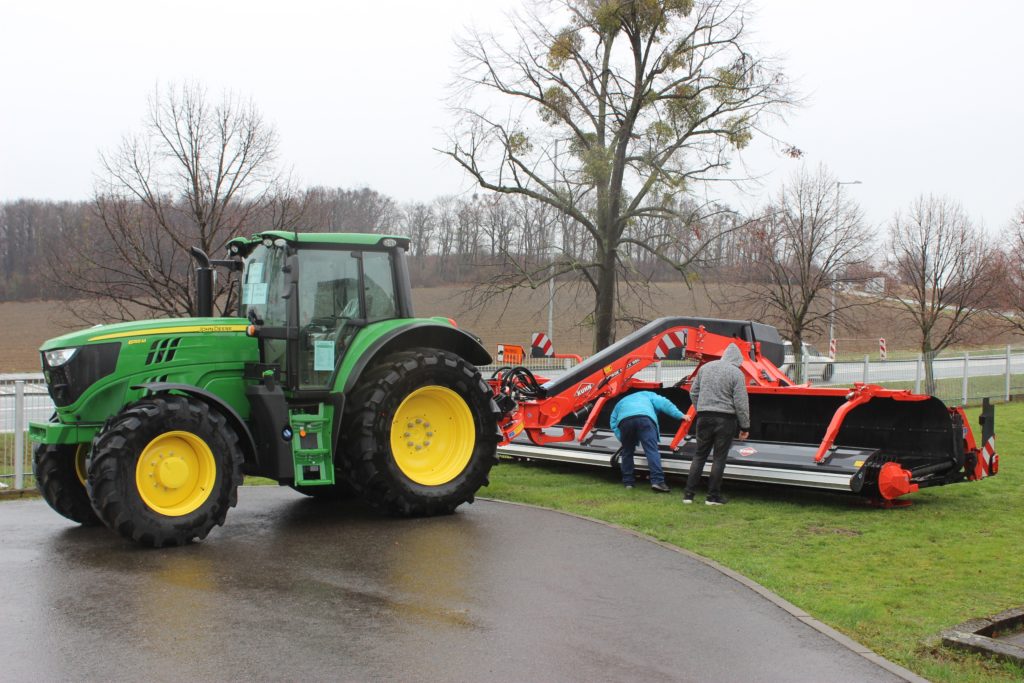 Traktor John Deere 6155M s pásovým shrnovačem Kuhn Merge Maxx 900 