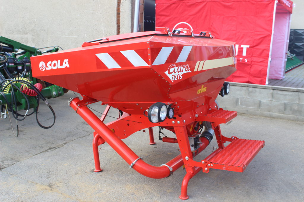 Pokud by do nakypřených pásů půdy mělo být místo kejdy aplikováno minerální hnojivo, pak si traktor veze zásobu hnojiva v čelně neseném zásobníku Sola Aura 3215. 