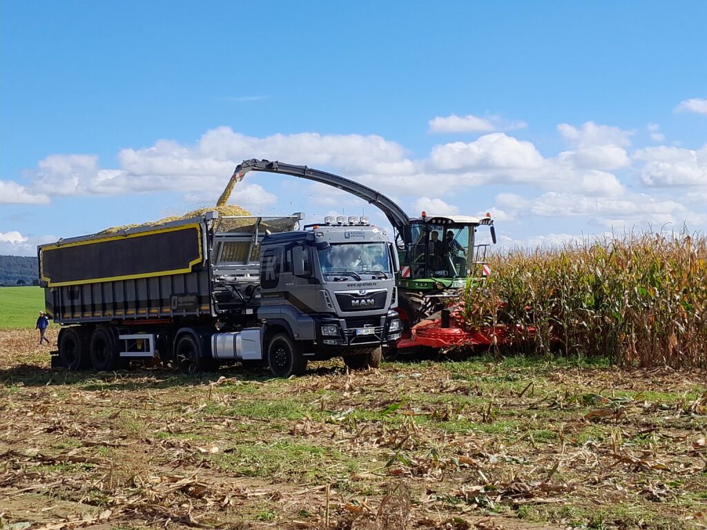 Dvounápravový návěs Kröger v sedlovém provedení s označením SAW 32 Agroliner plněný  řezačkou Fendt Katana 650