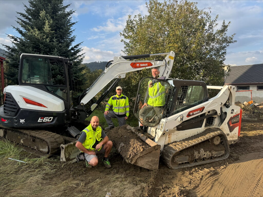 Výprava strojů s posádkou zahrnující smykem řízený pásový nakladač Bobcat T590 a minirypadlo Bobcat E60 zásadně pomáhá při pracích na likvidaci následků ničivých povodní.