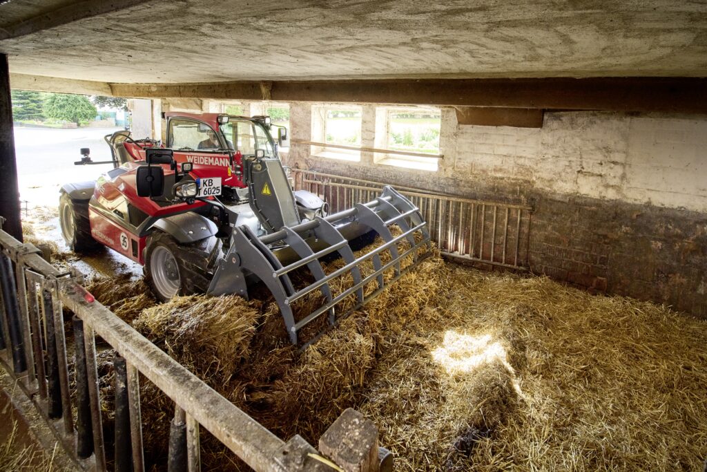 Weidemann T6025 při vyhrnování hnojné chodby