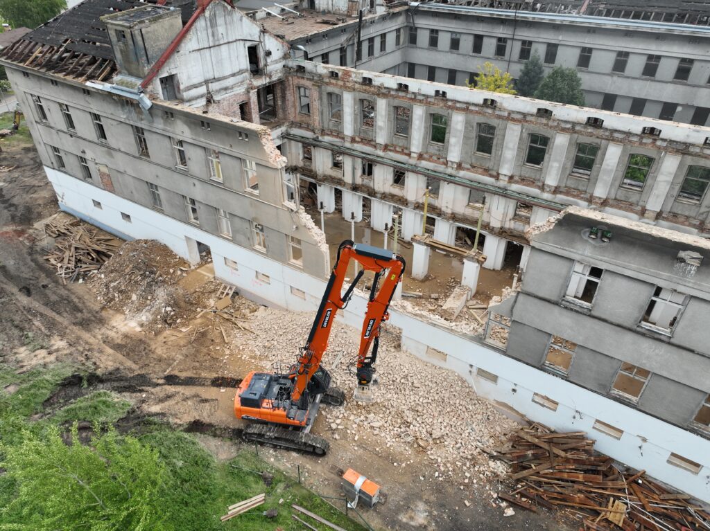 Na práci je pásové rypadlo DEVELON DX380DM-7 vybaveno sortýrovacím drapákem a především dlouhým demoličním ramenem.