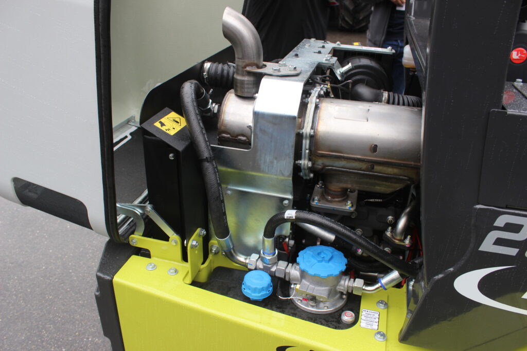 V zadní části má nakladač uložený motor značky Yanmar s třemi válci a výkonem 27 kW, tj. 37 k. Motor je ve svém zástavbovém prostoru usazen hodně nízko.