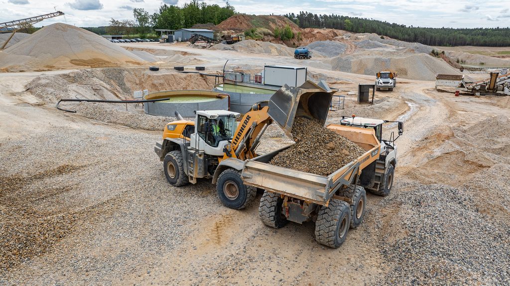 Dva kolové nakladače Liebherr L 576 XPower zásobují třídicí zařízení různými druhy hornin, skládkují materiál roztříděný podle frakce a nakládají jej na nákladní automobily.